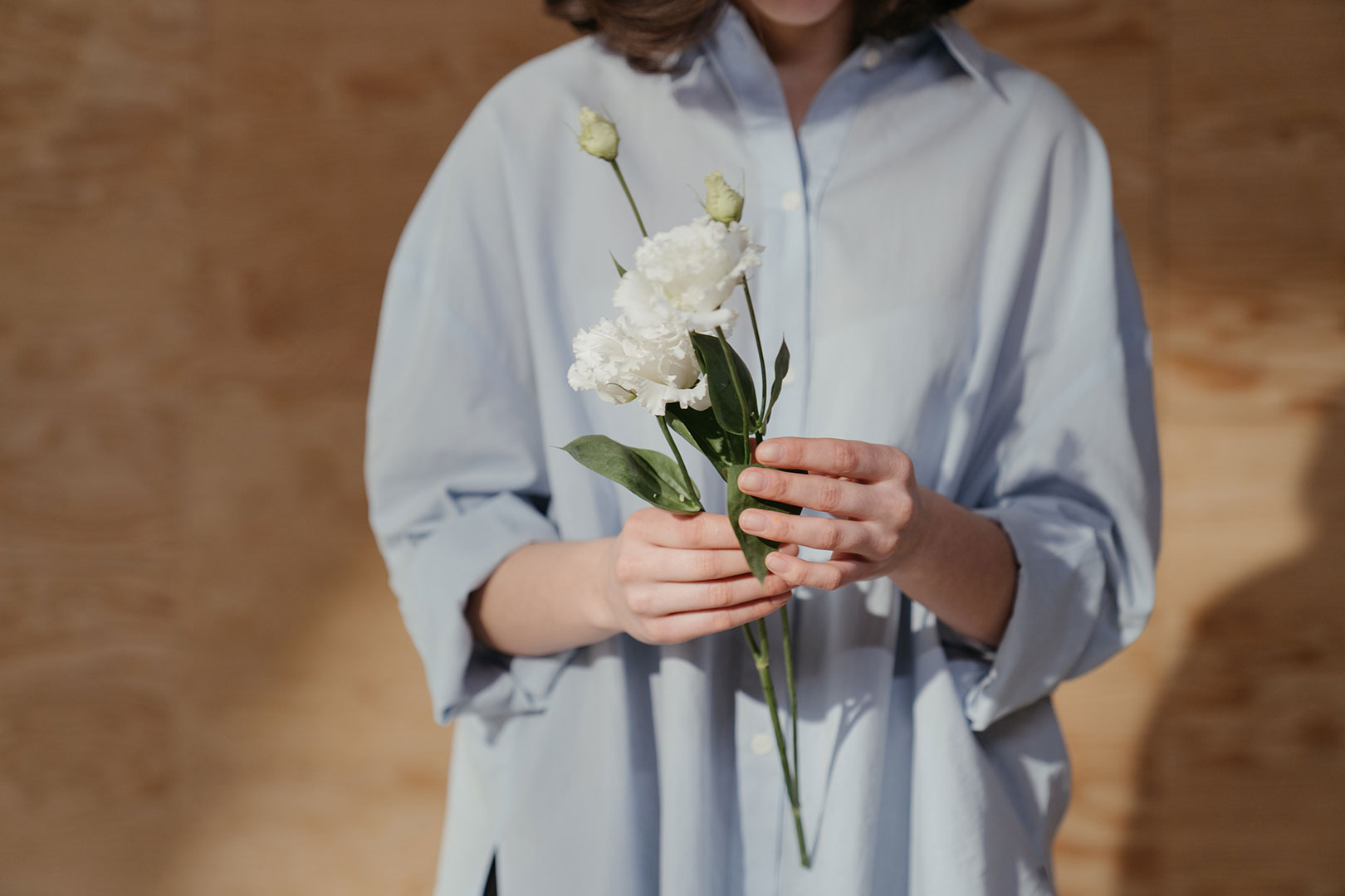 Une femme tient une fleur dans les mains